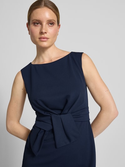 Frauenmodel trägt Knielanges Cocktailkleid mit Knotendetail von Vera Mont, Dunkelblau, Material-Mix mit Stretch-Anteil, Nahaufnahme Oberkörper.