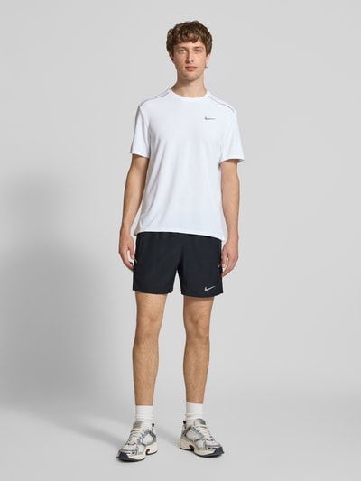 Männermodel trägt schwarze Shorts mit seitlichen Eingrifftaschen und Logo-Print von NIKE TRAINING, Loose-Fit, elastischer Bund, Ganzkörperansicht von vorne.