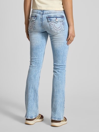 Vrouwenmodel draagt Flared Jeans in destroyed-look model 'BECCA' van TRUE RELIGION, mix van katoen en elastaan, flared cut, bandwijdte 40 cm, binnenbeenlengte 83 cm, lichte blauwe kleur, duidelijke stiksels en gewassen textuur. Ganzekörperansicht Rückansicht.