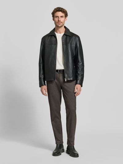 Männermodel trägt Tapered Fit Jogpants mit Viskose-Anteil Modell 'Phil' von Brax, Herren Weite Hose, Braunton, dezente Struktur, Ganzkörperansicht von vorne.