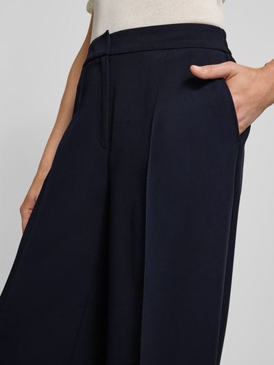 Frauenmodel trägt Weite Hose mit fixierten Bügelfalten von s.Oliver BLACK LABEL, Optik: Unifarben, Passform: Wide Leg, seitliche Eingrifftaschen, Verschluss: Schiebehaken und verdeckter Reißverschluss, Detailaufnahme
