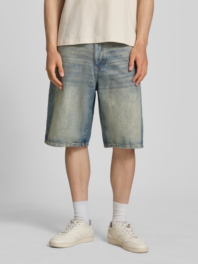 Männermodel trägt Jeansshorts im Used-Look mit Eingrifftaschen von REVIEW aus Reine Baumwolle, Relaxed-Fit, Ganzkörperansicht von vorne. Bundweite bei Größe M: 43 cm, Innenbeinlänge bei Größe M: 30 cm. Die Shorts zeigen blaue Denim-Farbe mit ausgewaschenen Partien und grober Textur.