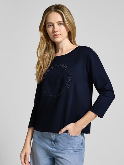 Vrouwenmodel draagt Relaxed Fit Sweatshirt met Viscose-aandeel model 'Emblem' van monari, donkerblauw, ronde hals, 7/8-mouw, vooraanzicht bovenlichaam.