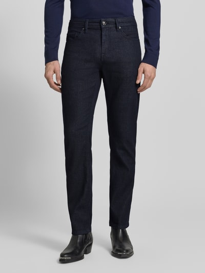 Männermodel trägt Straight Fit Jeans mit 5-Pocket-Design Modell 'Fortress' von JOOP! Collection in dunklem Blau, Baumwoll-Mix mit Stretch-Anteil, Gerader Schnitt, Knopf- und Reißverschluss, Ganzkörperansicht von vorne.