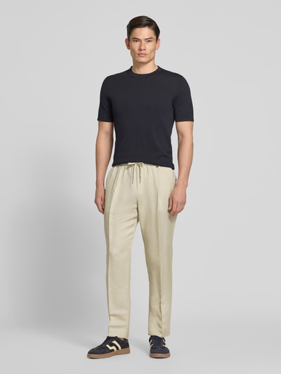 Männermodel trägt Regular Fit Hose aus Leinen-Viskose-Mix Modell 'NEIL' von Antony Morato, helle Farbe, mit Bügelfalten, elastischer Bund, Herren Hose, Ganzkörperansicht von vorne, Bundweite bei Größe 50: 44 cm, Innenbeinlänge bei Größe 50: 74 cm.