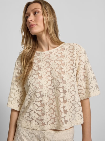 Frauenmodel trägt Semitransparentes Blusenshirt mit Rundhalsausschnitt von Jake*s Collection aus Baumwoll-Mix, Boxy-Fit, cremefarben mit floraler Spitzenstruktur, Rückenlänge 47 cm, Ärmellänge 29 cm, Semitransparente-Optik, Ganzkörperansicht von vorne.