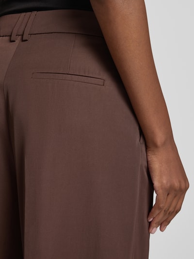 Männermodel trägt spodnie z zakładkami w pasie Wide Leg Bundfaltenhose mit Gesäßtaschen von Christian Berg Cocktail, Mieszanka materiałów z lyocellem, efekt błyszczący, kieszenie z tyłu, brązowe, zbliżenie na tylną część