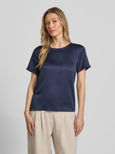 Kobiece modelka nosi Regular Fit Bluse aus Satin von Christian Berg Woman Selection, granatowa satyna, okrągły dekolt, bluzka z krótkim rękawem, długość tyłu w rozmiarze 36: 56 cm, długość rękawów w rozmiarze 36: 20 cm, zdjęcie w ujęciu całej sylwetki z przodu.