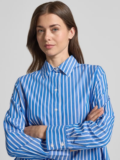 Frauenmodel trägt Relaxed Fit Langarmbluse aus reiner Baumwolle von s.Oliver RED LABEL mit blau-weißem Allover-Streifenmuster, Nahaufnahme Oberkörper.
