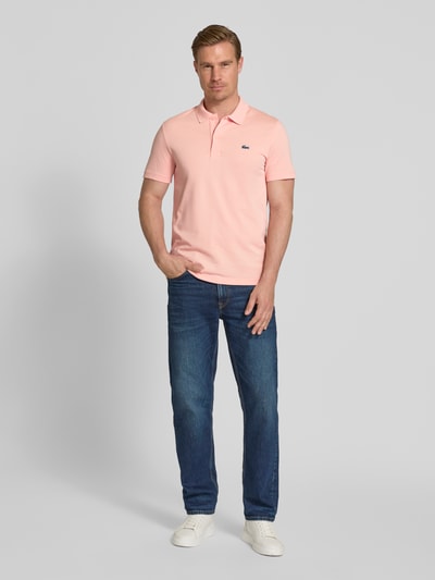 Männermodel trägt Regular Fit Poloshirt aus Baumwoll-Mix von Lacoste, Optik: Unifarben, Logo-Patch, Polokragen, Kurzarm, Ganzkörperansicht von vorne.