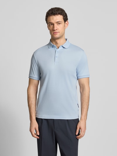 Męski model nosi Slim Fit Poloshirt mit Label-Detail von HECHTER PARIS, mieszanka bawełny, kołnierzyk polo, elastyczne wykończenia, kolor jasnoniebieski, długość tyłu w rozmiarze M: 70 cm, krój slim fit, ganzkörperansicht z przodu.