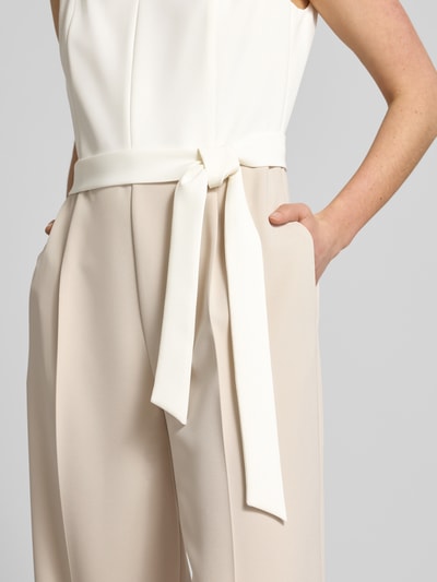 Vrouwenmodel draagt Regular Fit Jumpsuit mit Taillengürtel zum Binden van s.Oliver BLACK LABEL in two tone look, twill structuur, zijkantzakken, detailopname taille.