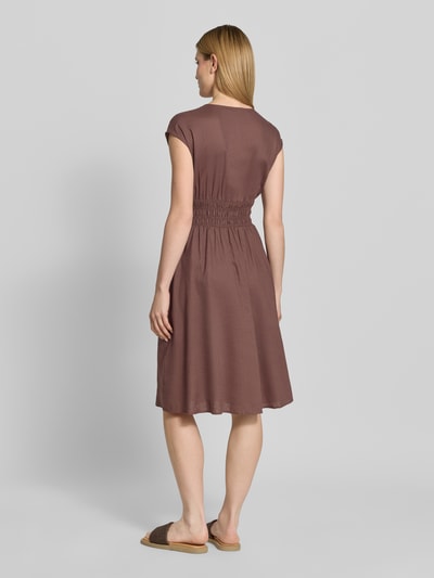 Frauenmodel trägt knielanges Kleid aus Leinen-Mix mit Knopfleiste von Christian Berg Woman Selection in Braun, Smok-Detail, Kappärmel, Taillierter Schnitt, V-Ausschnitt, Rückenlänge 44 cm, Brustweite 44 cm, Ganzkörperansicht Rückansicht.