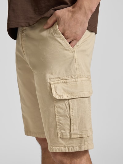 Männermodel trägt Bermudas mit Cargotaschen von bugatti in Beige, Regular Fit, sichtbare Cargotaschen, Nahaufnahme Oberschenkel seitlich.