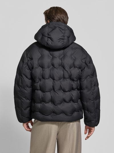 Männermodel trägt Regular Fit Steppjacke mit Rumftunnelzug Modell 'Barbo2641' von HUGO, Schwarz, Struktur, Ganzkörperansicht Rückansicht.