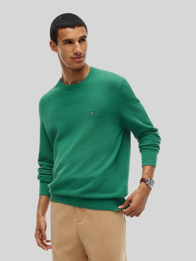 Mannenmodel draagt Regular Fit Pullover uit zuivere katoen van Tommy Hilfiger in effen groen, textuur gebreid, Ganzkörperaanzicht van voren.