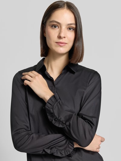 Frauenmodel trägt Hemdbluse aus Baumwoll-Mix Modell 'Mattie' von MOS MOSH, schwarz, Rüschen am Ärmel, Nahaufnahme Oberkörper.