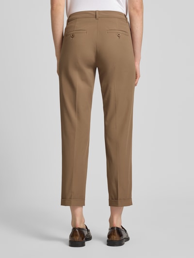 Frauenmodel trägt Chino aus Techno Cotton Superstretch Modell 'UTE' von Raffaello Rossi in Braun mit Bügelfalten, Verkürzt, Ganzkörperansicht Rückansicht. Elastischer-Material-Mix, Straight Fit, Knopf-Reißverschluss, Eingriffstaschen, Gesäßtasche, Beinumschläge, Gürtelschlaufen, Bundweite bei Größe 36: 40 cm, Innenbeinlänge 68 cm.
