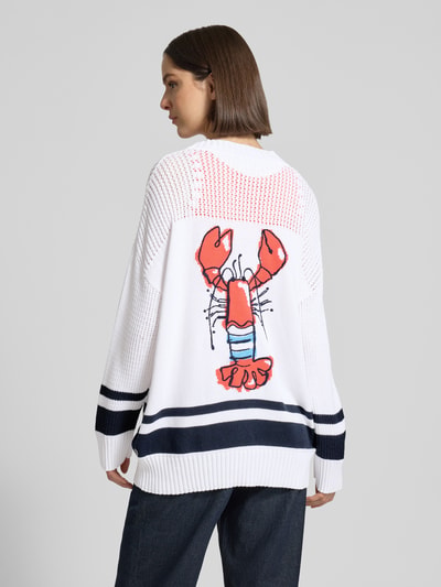 Frauenmodel trägt Cardigan mit überschnittenen Schultern und V-Ausschnitt von Marc Cain, Reine Baumwolle, Loose-Fit, Knopfleiste, Rückenlänge bei Größe 38: 68 cm, Ärmellänge bei Größe 38: 48 cm, weiß mit dunkelblauen Streifen und farbigem Hummermotiv, Strukturstrick, Ganzkörperansicht Rückansicht.