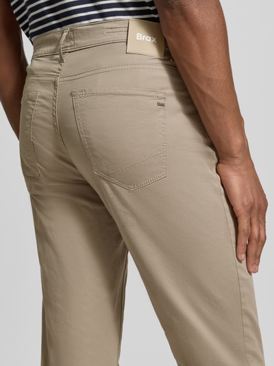 Męski model nosi Hose mit Eingrifftaschen Modell 'Chuck' von Brax, beżowe, bawełniany miks z lyocellem, krój slim fit, szerokość w rozmiarze 32/32: 43 cm, długość nogawki wewnętrznej: 81 cm, detaliczne ujęcie tylnej partii spodni.