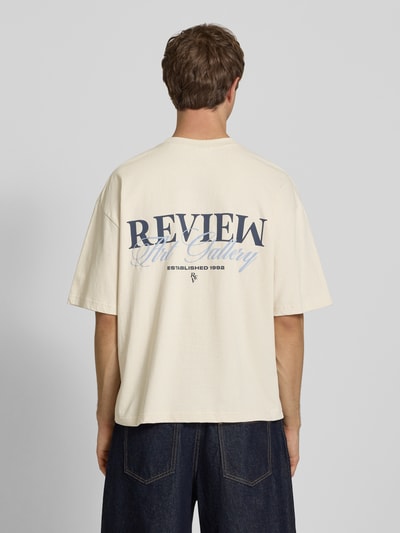 Männermodel trägt T-Shirt mit Label-Detail von REVIEW in Beige, reine Baumwolle, lockerer Schnitt, Rückenlänge 66 cm, Ganzkörperansicht Rückansicht.