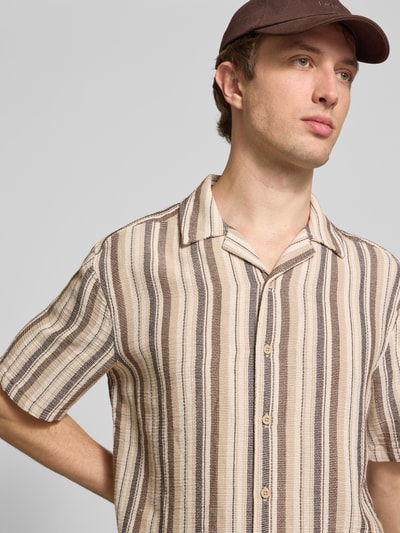 Männermodel trägt Regular Fit Freizeithemd aus Baumwoll-Mix Modell 'TREV LIFE' von Only & Sons mit beigem, braunem Struktur-Streifenmuster, Resortkragen und durchgehender Knopfleiste, Nahaufnahme Oberkörper.