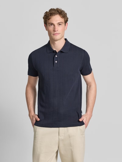 Männermodel trägt Regular Fit Poloshirt mit kurzer Knopfleiste von Lindbergh, Reine Baumwolle, Jaquard-Strick, Polokragen, Ganzkörperansicht von vorne.