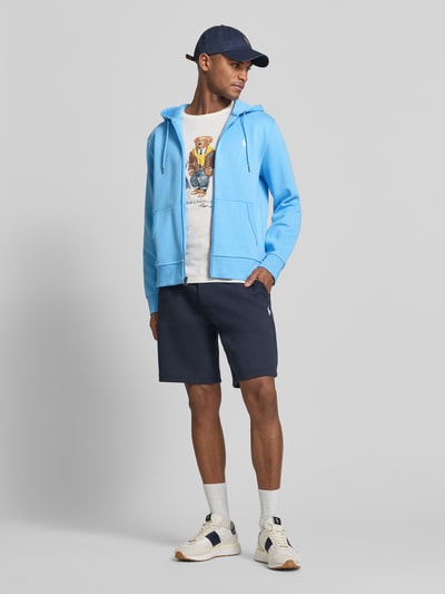 Męskimodel nosi Regular Fit Sweatjacke aus Baumwoll-Mix von Polo Ralph Lauren, efekt: jednolity kolor, krój regular fit, zamek błyskawiczny, wyhaftowane logo, kaptur z tunelem, długi rękaw, wykończenie: dzianina dresowa, mieszanka bawełny; całopostaciowy widok z przodu.
