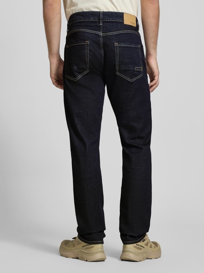 Männermodel trägt Regular Fit Jeans aus Baumwoll-Mix Modell 'Cash' von Pepe Jeans in dunklem Denim mit Label Patch und 5-Pocket-Design, Ganzkörperansicht Rückansicht.