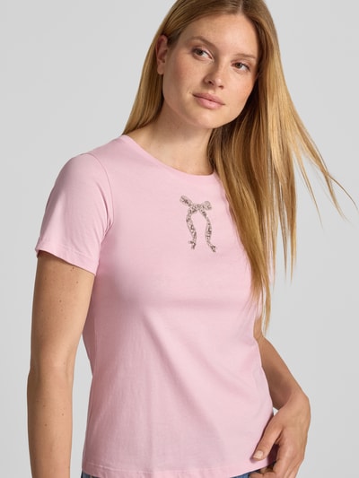 Frauenmodel trägt T-Shirt mit Perlen und Rundhalsausschnitt Modell 'Tamme' von JOOP! aus reiner Baumwolle in Rosa, Nahaufnahme Oberkörper.