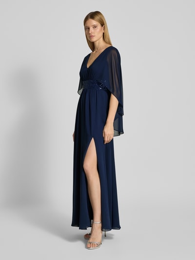 Kobiece modelka nosi Abendkleid mit Taillenband und Pailletten von SWING, szyfon, linia A, długa sukienka, dekolt w serek, tasiemka w talii z cekinami, długość tyłu w rozmiarze 36: 149 cm, szerokość klatki piersiowej w rozmiarze 36: 35 cm, widok całej sylwetki z przodu.