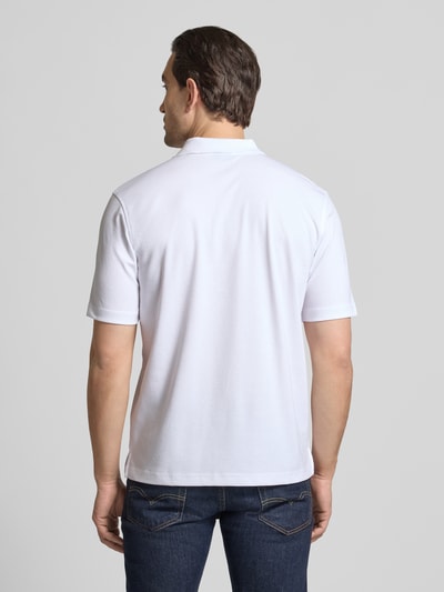 Männermodel trägt Regular Fit Poloshirt mit Brusttasche von Christian Berg Men aus Material-Mix mit Baumwoll-Anteil, Ganzkörperansicht Rückansicht.