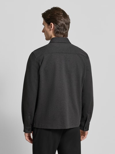 Männermodel trägt Oversized Hemdjacke aus Baumwoll-Mix Modell 'ENASO' von HUGO in dunkler Melange-Optik, Ganzkörperansicht Rückansicht.