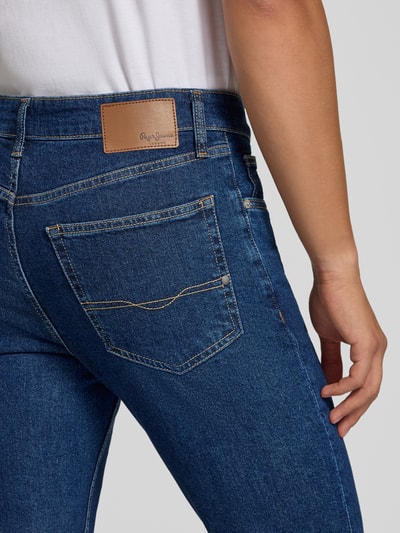 Männermodel trägt Slim Fit Jeans aus Baumwoll-Mix Modell 'Hatch' von Pepe Jeans, blau, strukturierte Oberfläche, Nahaufnahme Rückansicht, Herren Slim Fit Jeans von Pepe Jeans.
