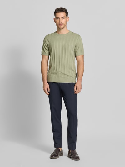 Männermodel trägt Strickshirt aus Viskose-Mix mit Rundhalsausschnitt von Lindbergh in heller Grünton, Ripp-Optik, Regular-Fit, Ganzkörperansicht von vorne. Rückenlänge bei Größe M 69 cm, Ärmellänge 24 cm.
