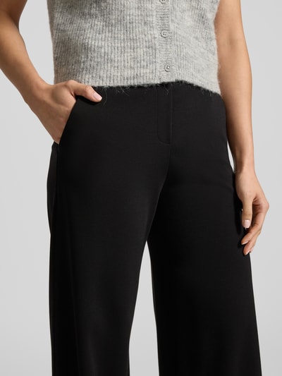 Frauenmodel trägt Stoffhose mit französischen Eingrifftaschen Modell 'NALEY' von SEDUCTIVE in Schwarz, lockerer Schnitt, Nahaufnahme Oberkörper. Viskose-Mix mit Stretch-Anteil, Kontext Damen Stoffhose, moderne Optik.