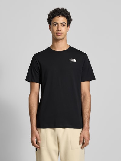 Männermodel trägt zwart Regular fit T-shirt aus katoenmix Modell 'EVOLUTION' van The North Face met ronde hals en labeldetail, ruglengte maat M 70 cm. Ganzkörperansicht von vorne.
