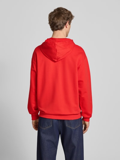 Männermodel trägt Relaxed Fit Hoodie mit Känguru-Tasche von PUMA PERFORMANCE in kräftigem Rot, reine Baumwolle, Rückenansicht Ganzkörperansicht.