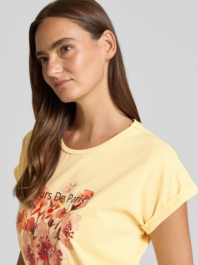 Frauenmodel trägt Damen T-Shirt mit Motiv-Print Modell 'RINA' von Soyaconcept in Hellgelb, Baumwoll-Elasthan-Mix, Regular-Fit, Rundhalsausschnitt, Ärmel mit Aufschlag, Nahaufnahme Oberkörper.