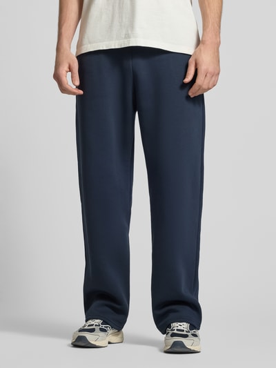 Männermodel trägt Sweatpants aus Baumwoll-Mix von REVIEW in Dunkelblau mit elastischem Bund, Seitentaschen, Gerader Schnitt, Nahaufnahme Oberschenkel.