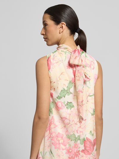 Vrouwenmodel draagt Fließendes Maxikleid mit Rüschendetail Modell 'SANNA' van Vero Moda, all-over bloemenmotief, chiffon, detailopname rugdecolleté met strik