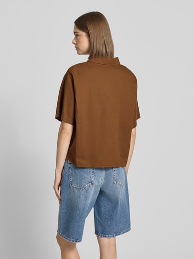 Modelka nosi Regular Fit Hemdbluse aus Leinen-Baumwoll-Mix od Marc O'Polo Denim, efekt: jednolity kolor, krój regular fit, kołnierzyk koszulowy, dekolt w serek, zapięcie: listwa guzikowa, rękaw: krótki rękaw, wykończenie materiału: cieniowana przędza, mieszanka lnu i bawełny, widok całej sylwetki z tyłu.
