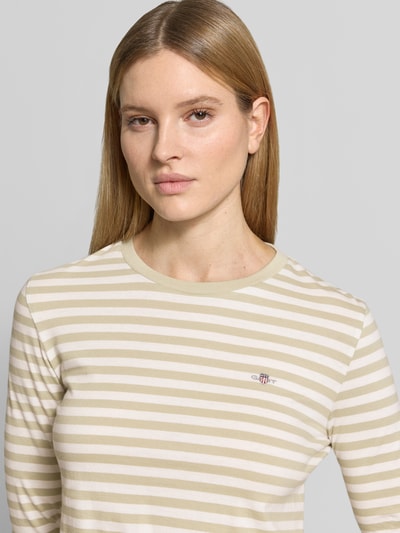 Frauenmodel trägt Longsleeve mit Label-Stitching von Gant in Beige-Weiß gestreift, Reine Baumwolle, Regular-Fit, Rundhalsausschnitt, Nahaufnahme Oberkörper.