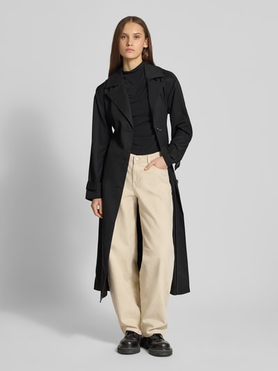 Frauenmodel trägt Regular Fit Trenchcoat in Longline Modell 'LINE' von ONLY, Optik: Unifarben, Reverskragen, einreihige Knopfleiste, Schulterriegel, Gehschlitz, Ärmelform: Langarm mit Riegel, seitliche Eingrifftaschen, Ganzkörperansicht von vorne.