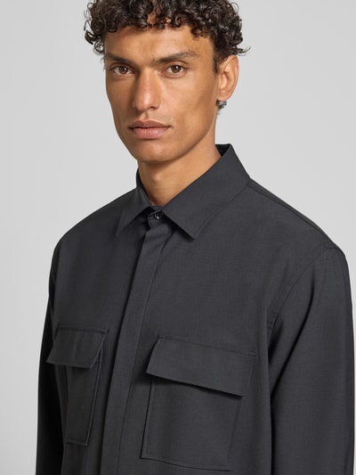 Männermodel trägt Relaxed Fit Hemdjacke mit Schurwoll-Anteil Model 'Arion' von DIGEL, dunkler Ton, glatte Textur, Nahaufnahme Oberkörper.