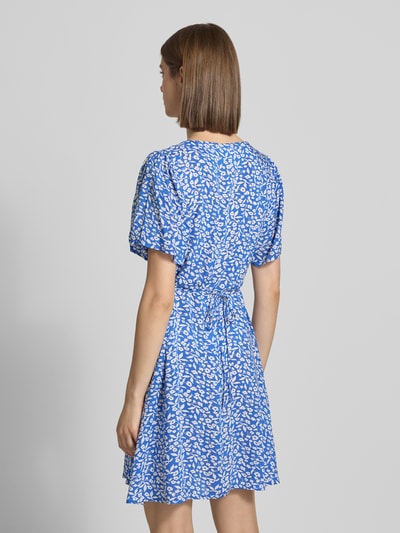 Frauenmodel trägt Minikleid aus reiner Viskose Modell 'EVIDA' von Only in Optik: Allover-Muster, Tailliert, Mini, Rückansicht.