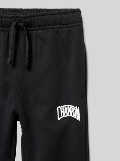 Produktfoto, schwarze Regular Fit Sweatpants aus Baumwoll-Mix mit elastischem Bund, Tunnelzug, Seitentaschen und Label-Detail von CHAMPION