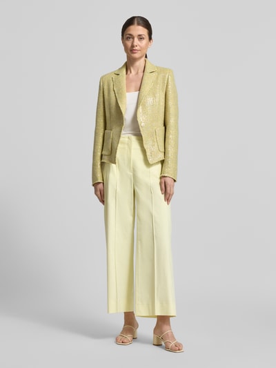 Frauenmodel trägt Slim Fit Blazer mit Pailletten von Luisa Cerano im Material-Mix mit Baumwoll-Anteil, Reverskragen und Aufgesetzte Taschen, Rückenlänge 55 cm, Brustweite 43 cm, Ärmellänge 65 cm, helle Gelb- und Cremetöne, glatte und glänzende Textur, Ganzkörperansicht von vorne.