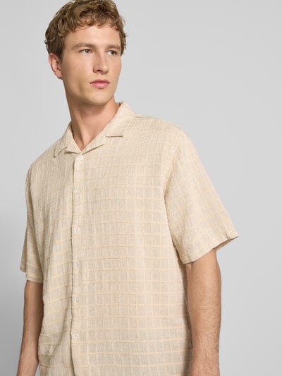 Männermodel trägt Oversized Freizeithemd mit Strukturmuster Modell 'Corey' von Redefined Rebel im Beige-Ton aus Baumwoll-Leinen-Mix, Knopfleiste, Reverskragen, Halbarm, Strukturmuster, Ganzkörperansicht von vorne. Rückenlänge 71 cm, Schulterbreite 53 cm, Ärmellänge 28 cm, Größe M.
