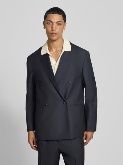 Männermodel trägt Regular Fit Sakko aus Woll-Mix von Officine Générale, dunkelblau, Doppelreiher, Reverskragen, Ganzkörperansicht von vorne.